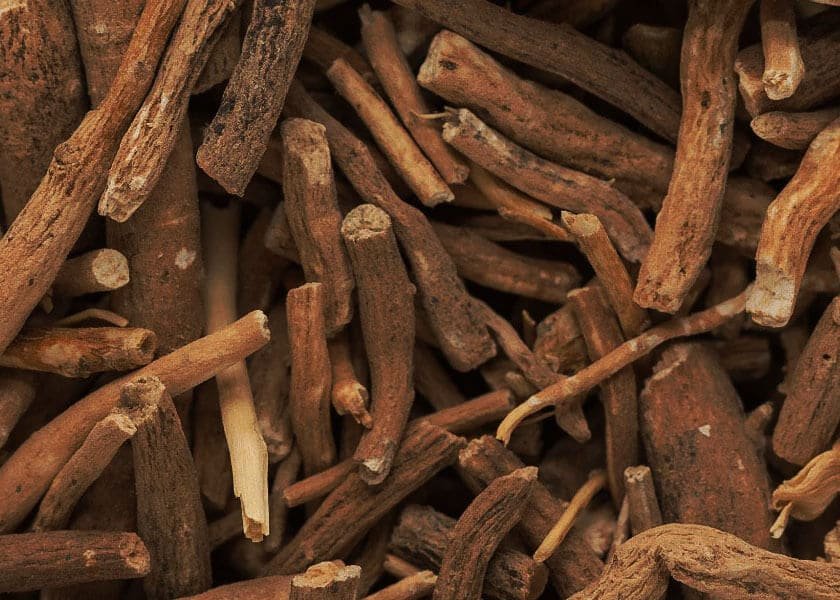 Close-up of fresh Ashwagandha roots on a natural wooden surface, highlighting the traditional medicinal herb known for supporting stress resilience and overall wellness.